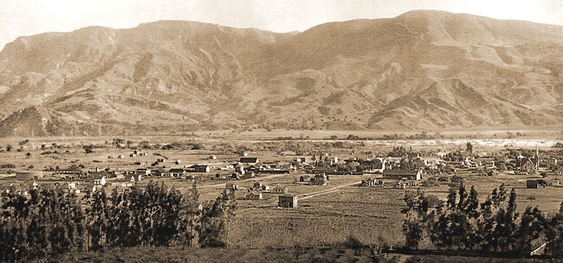 A few scattered homes, farms, and commercial buildings in Santa Paula in 1888. Santa Clara River flows along mountains  south of the city.